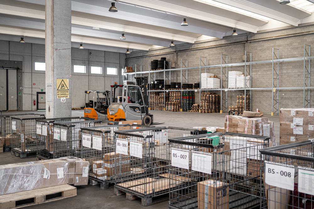 Magazzino Ital Log con contenitori in rete e carrelli elevatori per la movimentazione merci